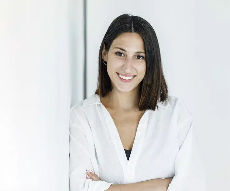 Xiomara Pérez, diseñadora web, sonriendo con los brazos cruzados