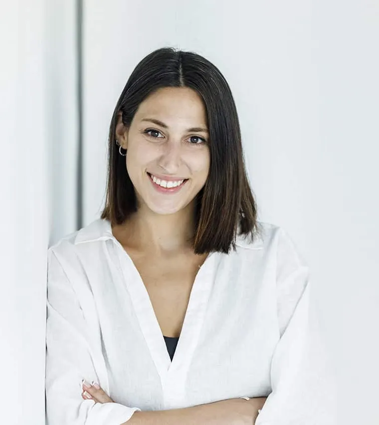 Xiomara Pérez, diseñadora web freelance, sonriendo con los brazos cruzados
